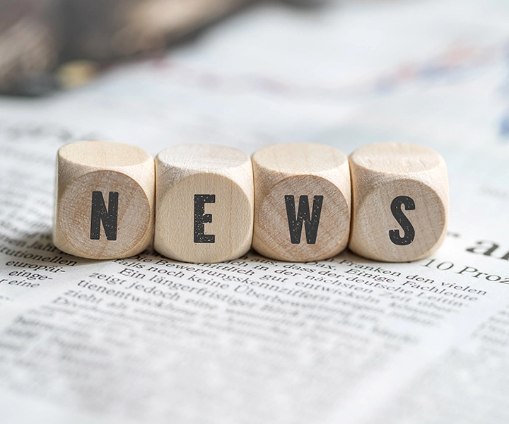 Bloques con la palabra «NOTICIAS» sobre un periódico.