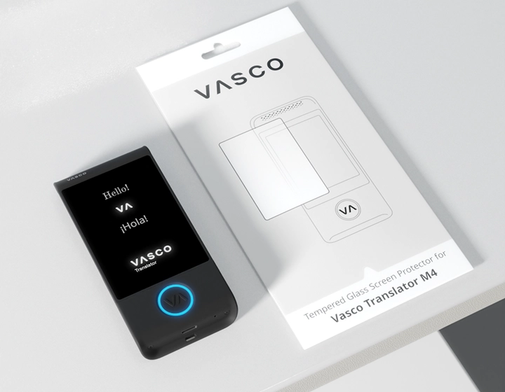 Vasco Translator M4 with a glowing blue LED on the button with the Vasco logo, lying on a table next to packaging for a screen protector for the Vasco Translator M4.