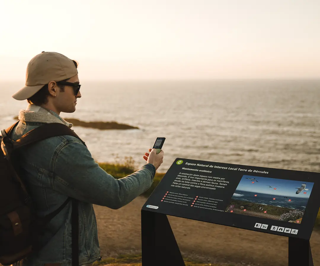 un hombre en la hermosa playa que usa un traductor de fotos para leer un letrero con información turística sobre su ubicación